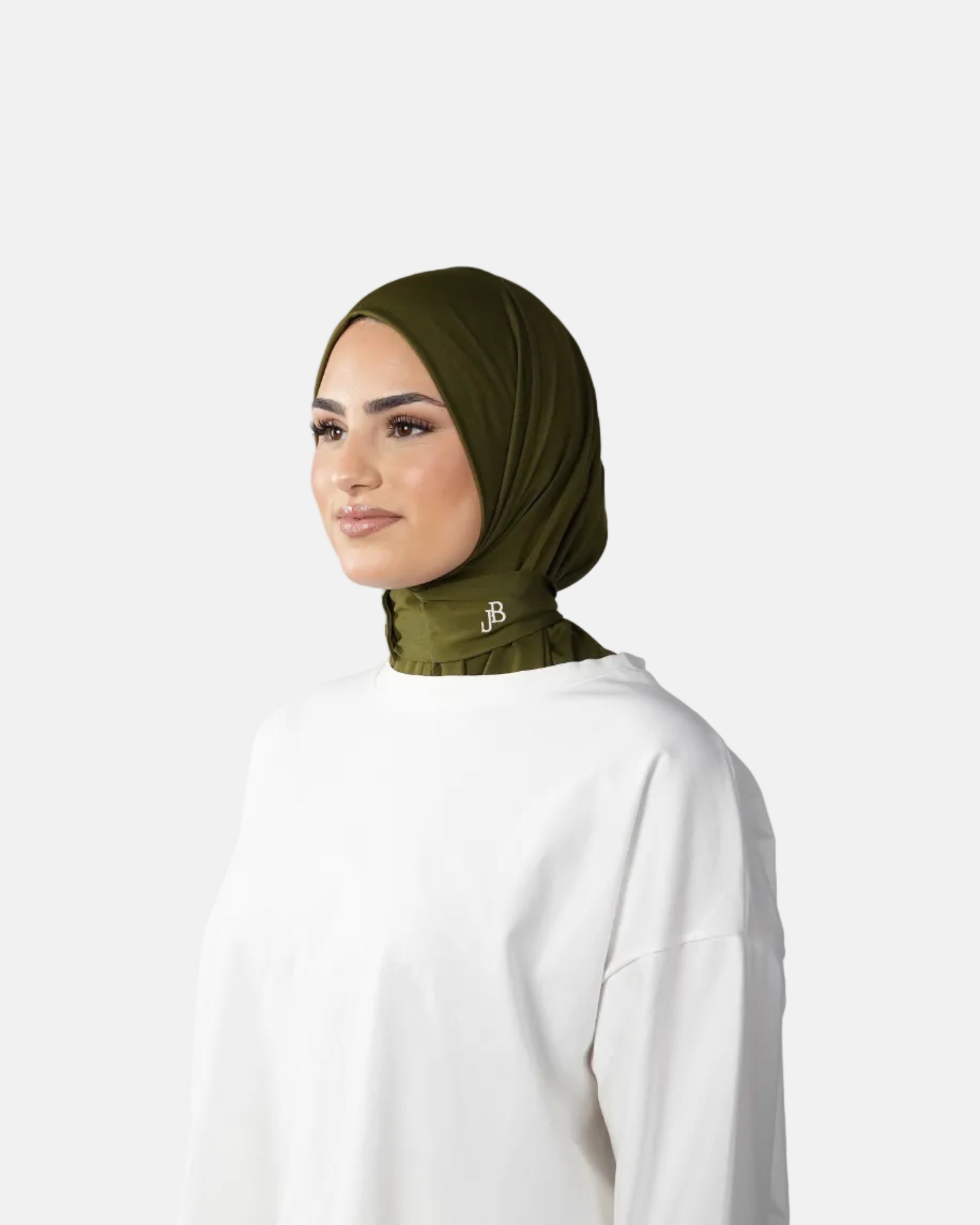 Woman wearing a green hijab and white outfit on a gray background