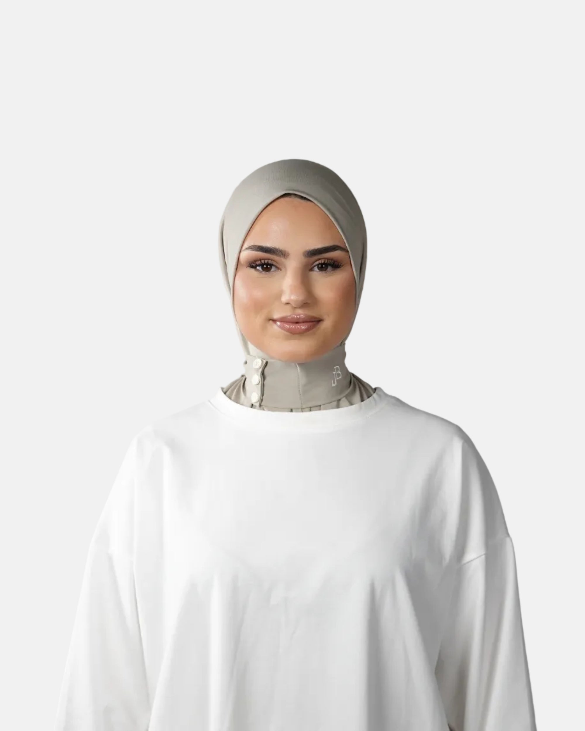 Woman wearing a white outfit and headscarf against a gray background
