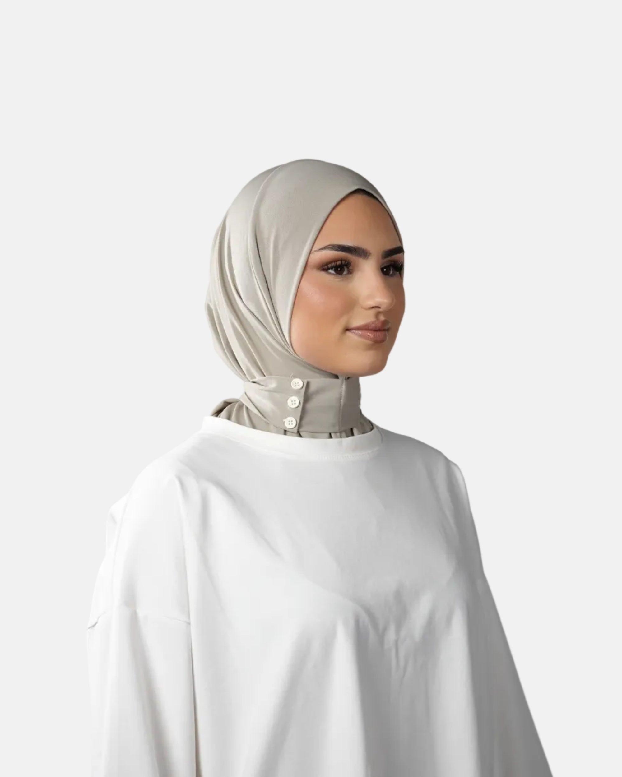 Woman wearing a beige hijab and white top against a gray background