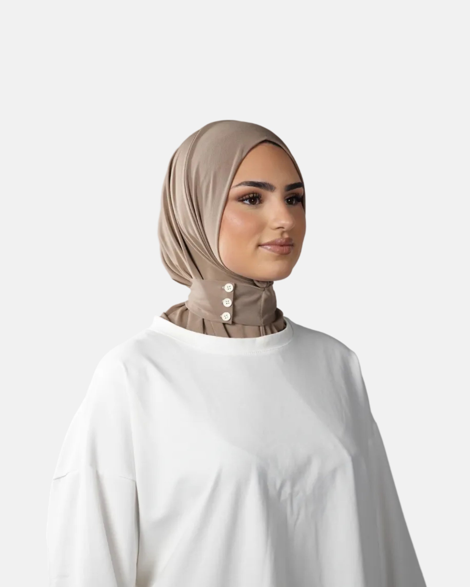 Woman wearing a beige hijab and white shirt against a gray background