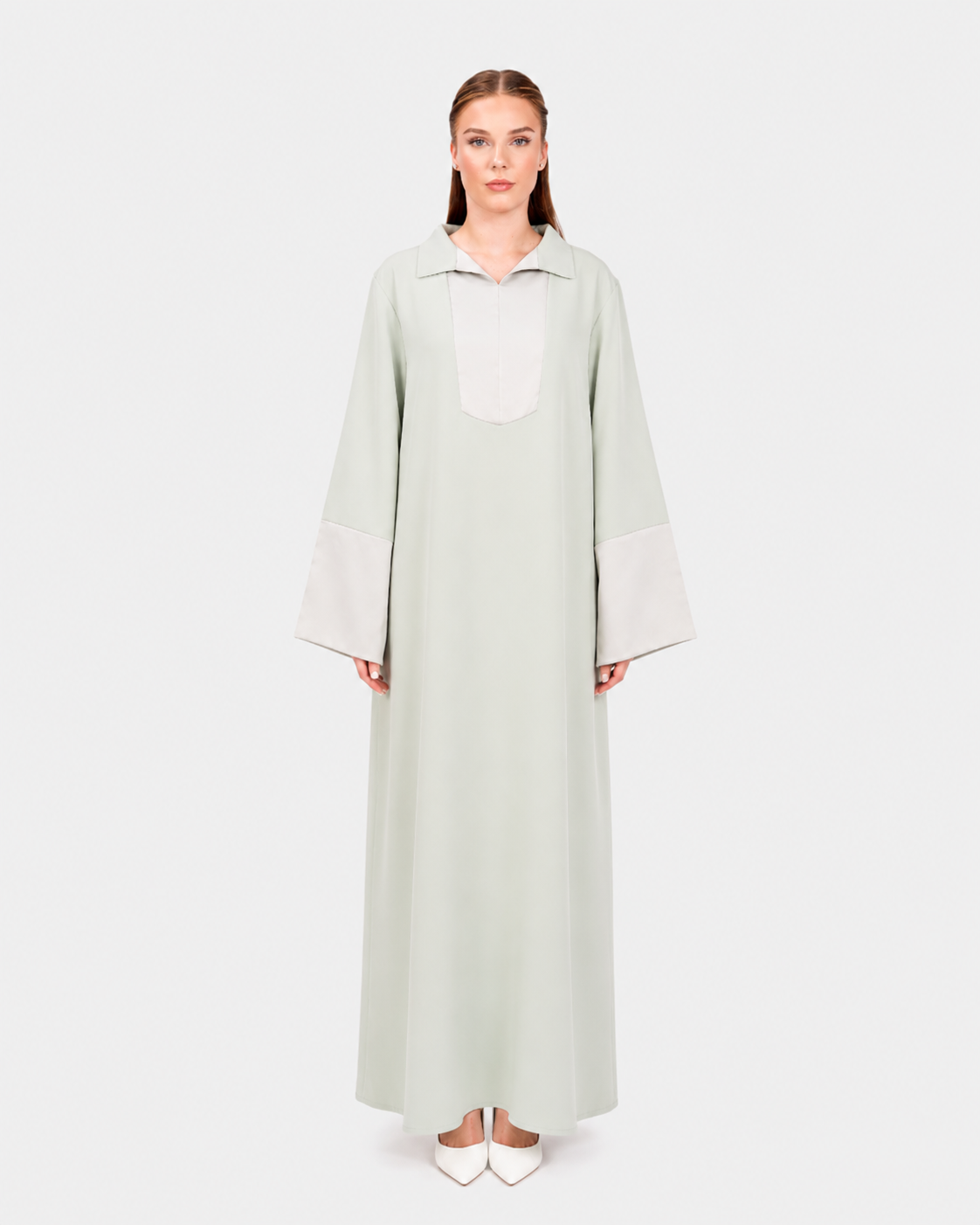 Woman wearing a light green long dress on a white background